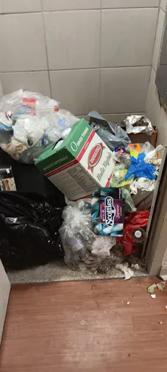 a pile of trash near a garbage chute.