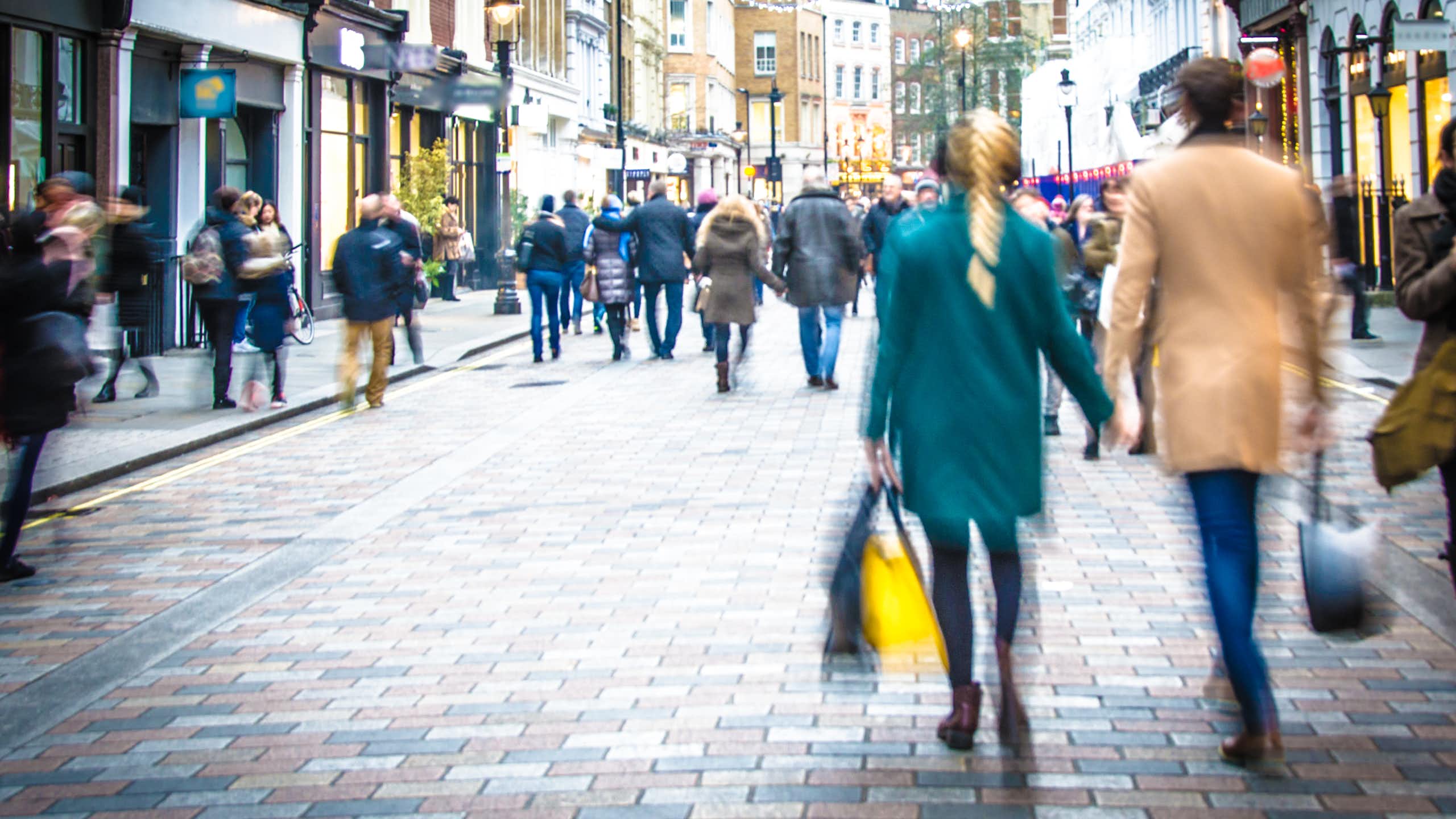 people walking down a pedestrianised shopping street