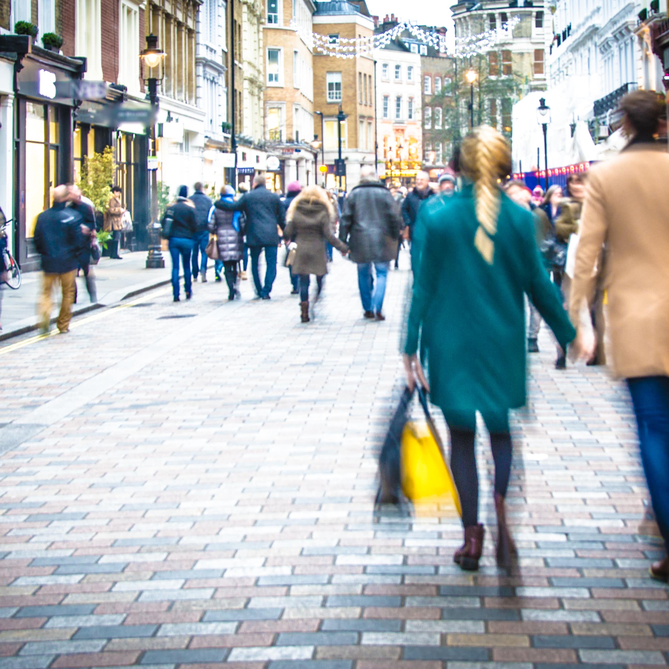 people walking down a pedestrianised shopping street