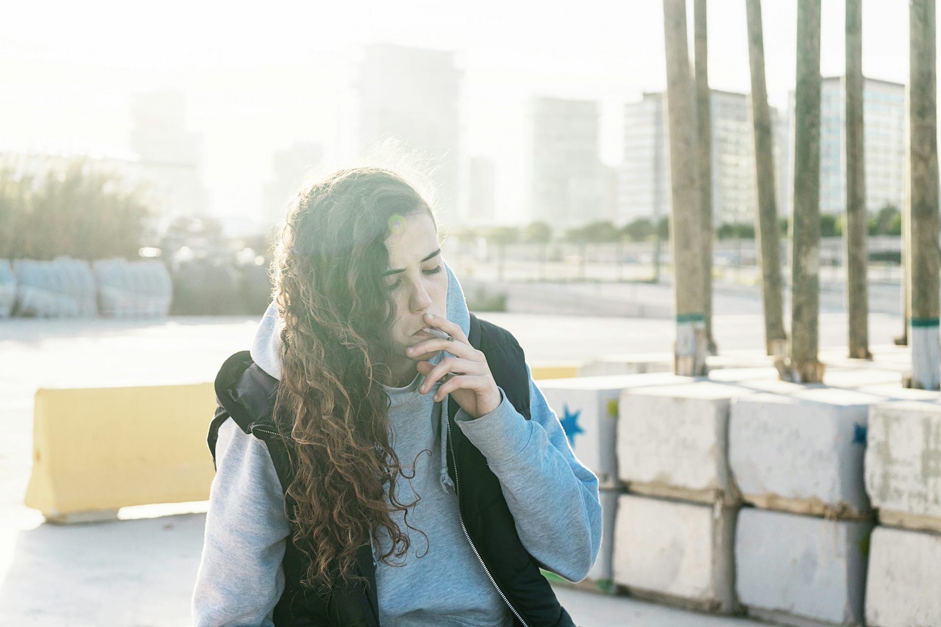 A young girl smokes a marijuana cigarette.