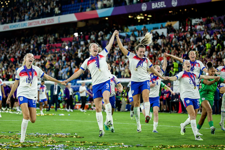 Members of England's women's football team celebrate with fans.