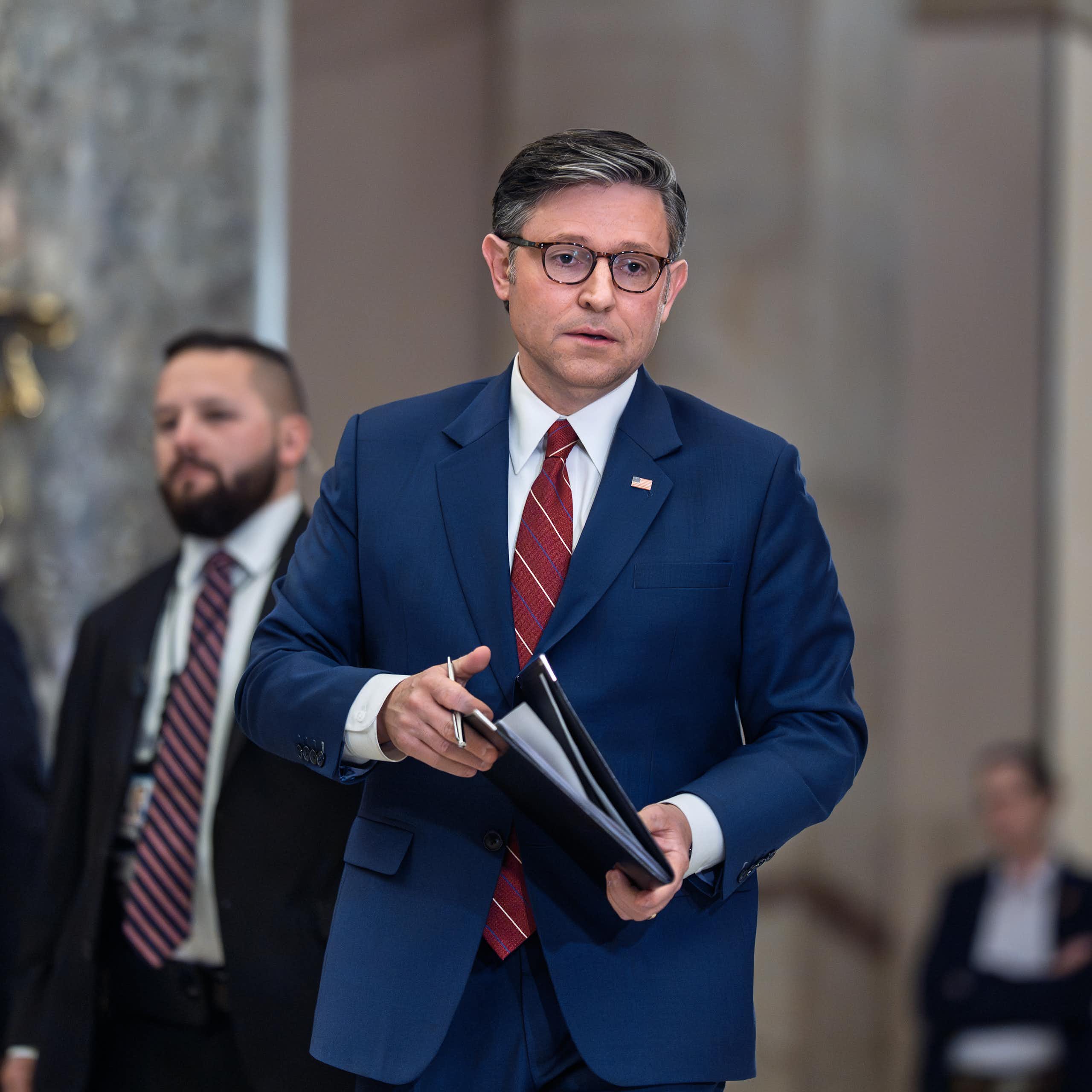 House Speaker Mike Johnson walks down a corridor in Congress.