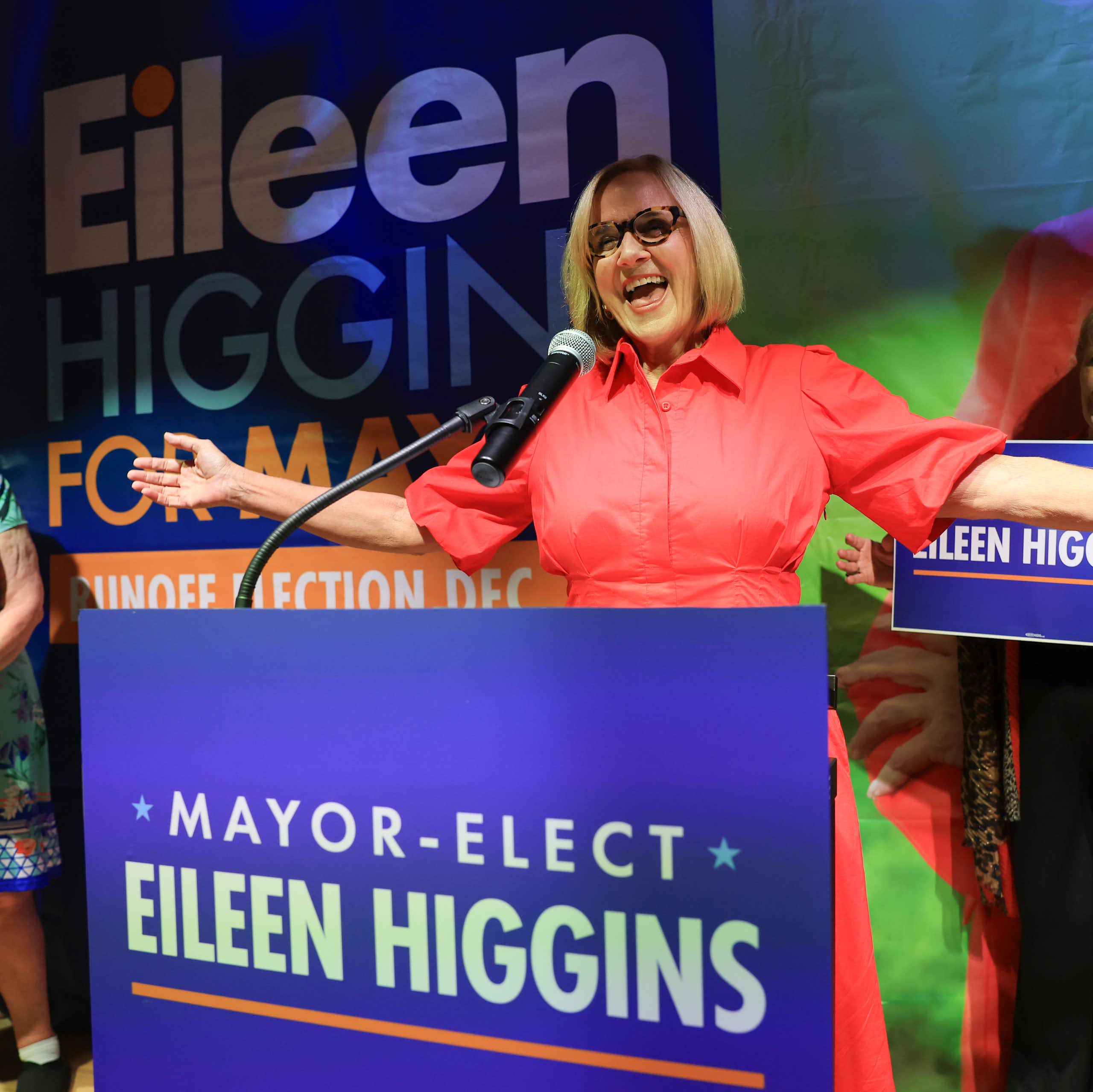 Eileen Higgins smiles while standing behind a podium that says 'Mayor-elect Eileen Higgins.'