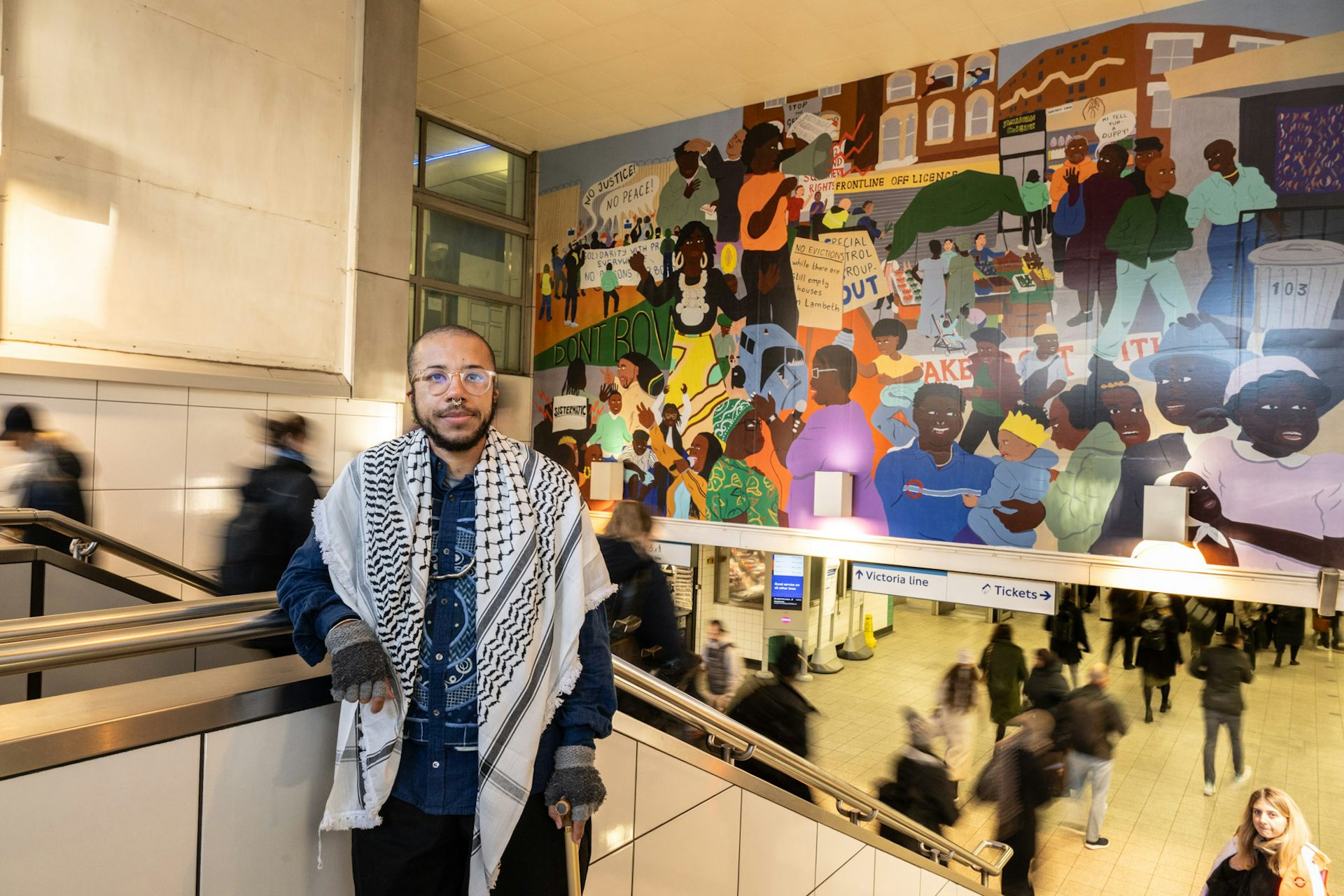 A young black person standing on the steps at Brixton underground station.