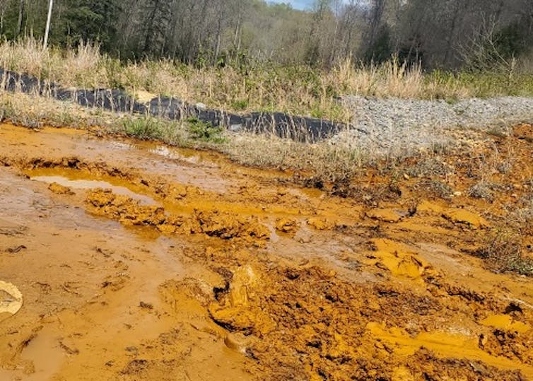 Metals flowing from acid mine waste make a creek look orange.