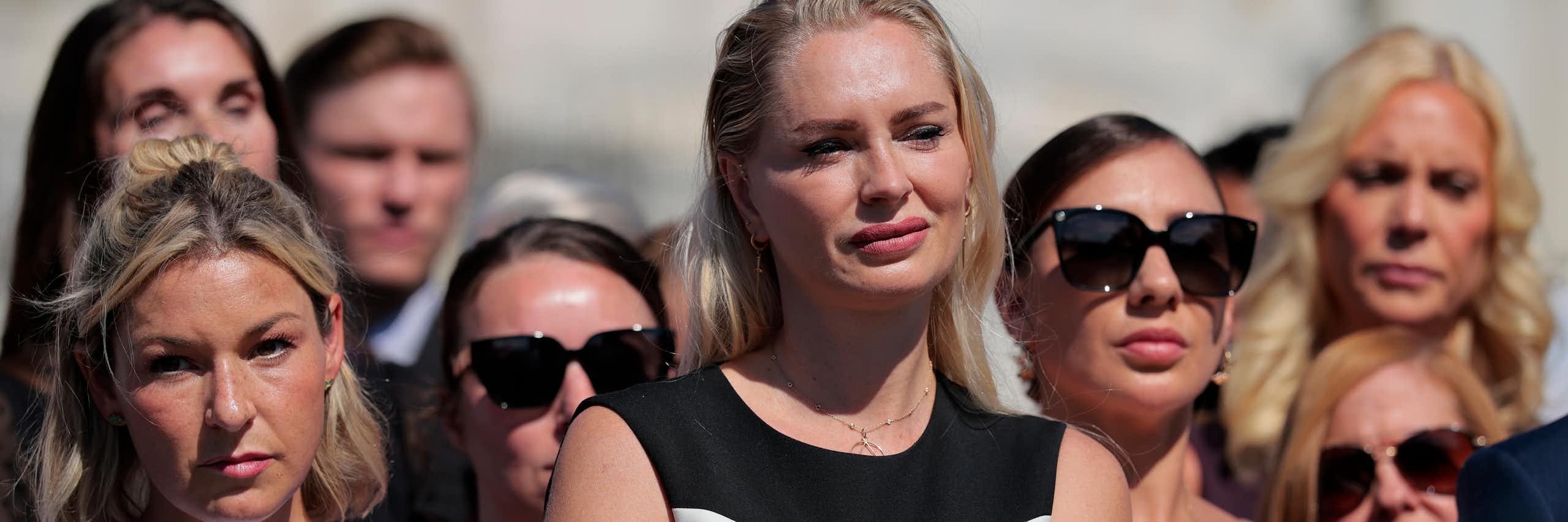 Women standing outside looking at someone not in the photo.