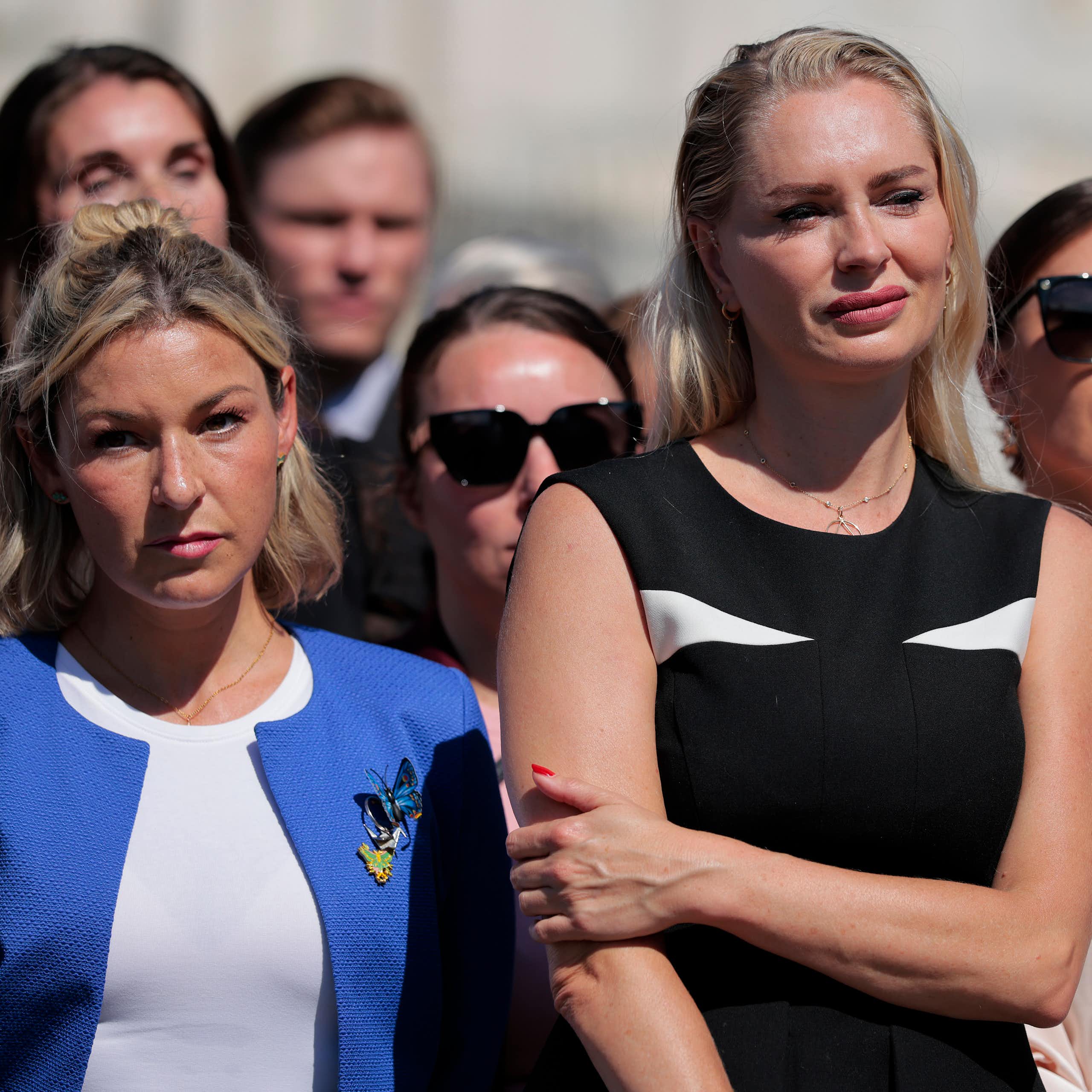 Women standing outside looking at someone not in the photo.
