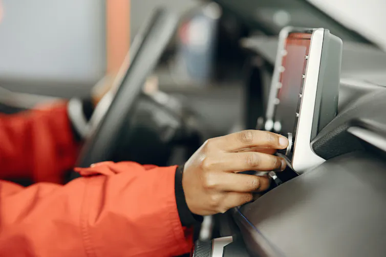 Person adjusts their car stereo