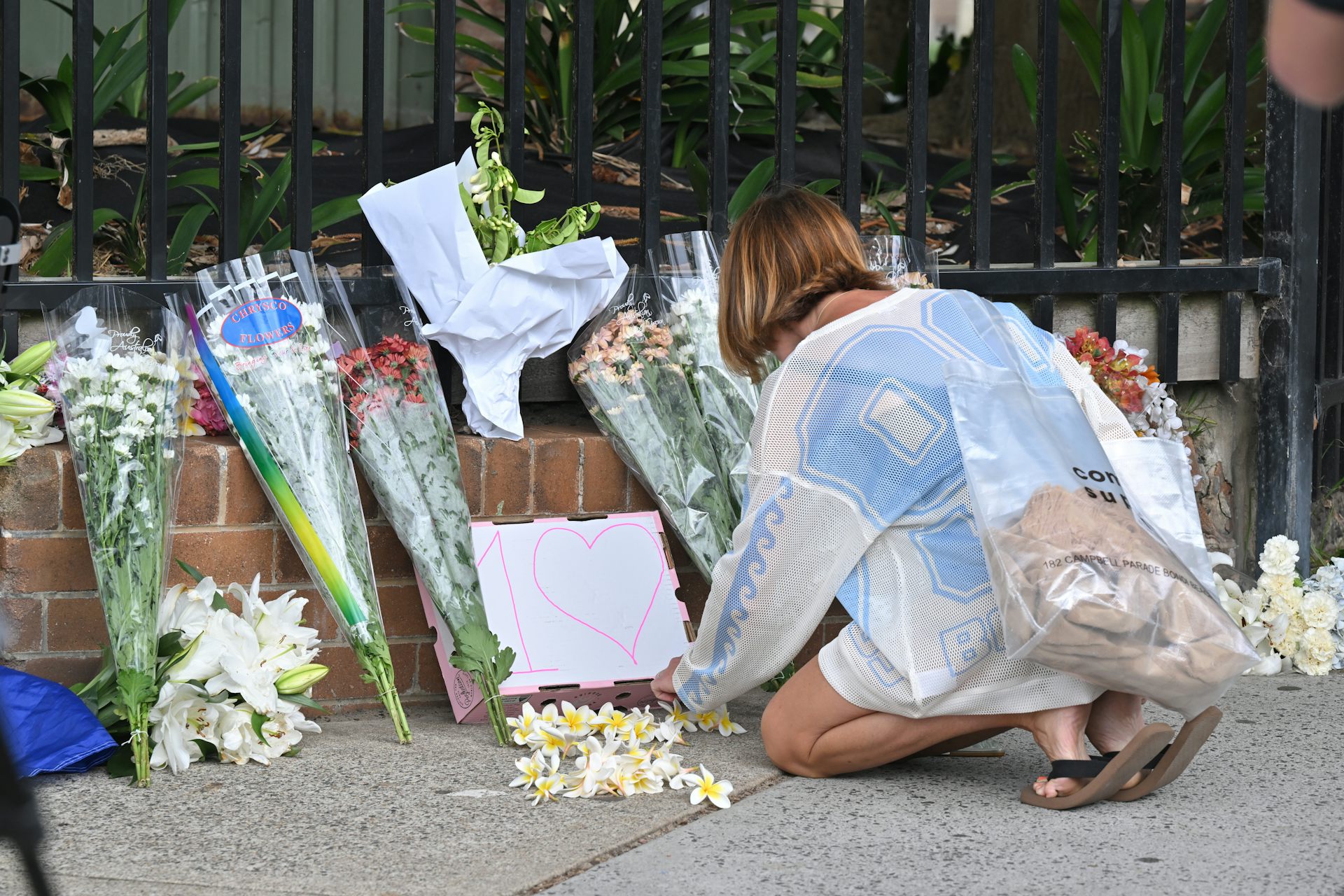 A woman lays flowers at the site of the Bondi attack
