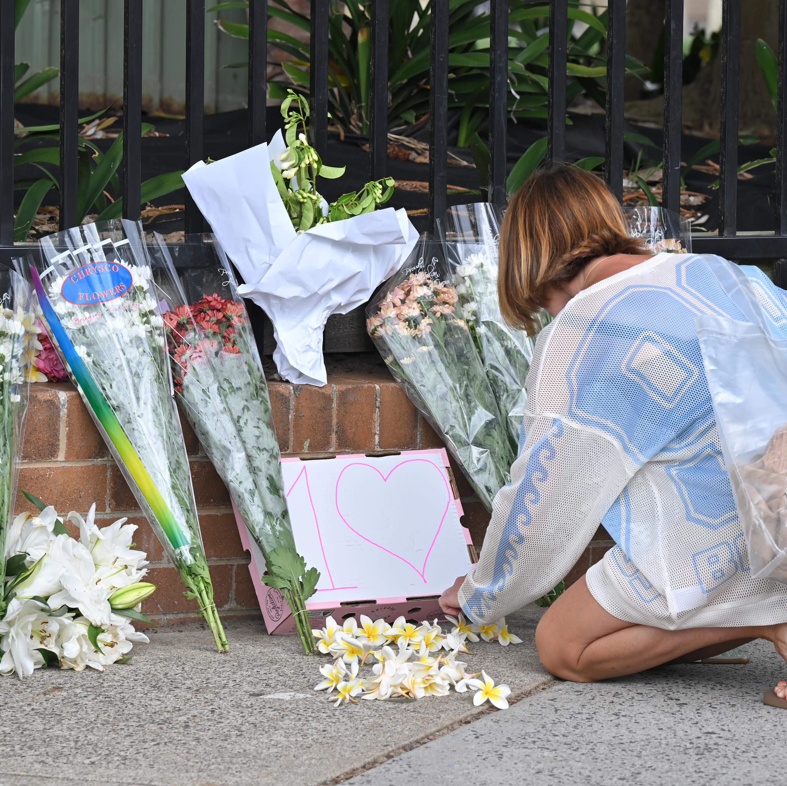 A woman lays flowers at the site of the Bondi attack