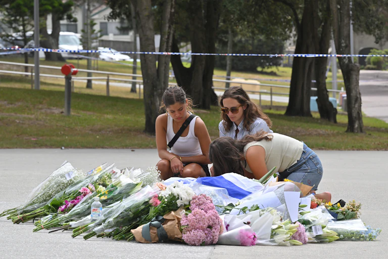 Mourners placing flowers at a makeshift memorial at Bondi Beach in Sydney, Monday, December 15, 2025