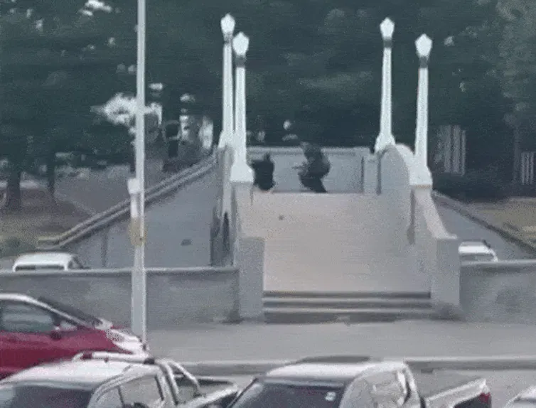 The gunman returns to the bridge and re-arms.