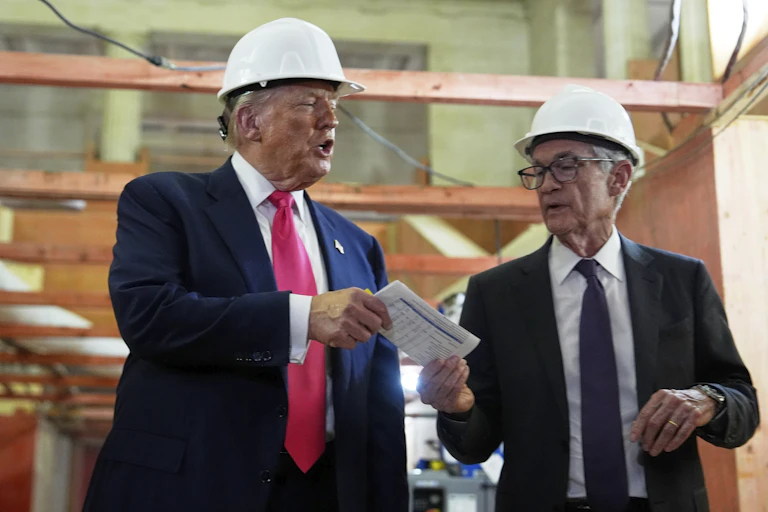 President Donald Trump hands a document of cost figures to Federal Reserve Chairman Jerome Powell during a visit to the Federal Reserve in July.