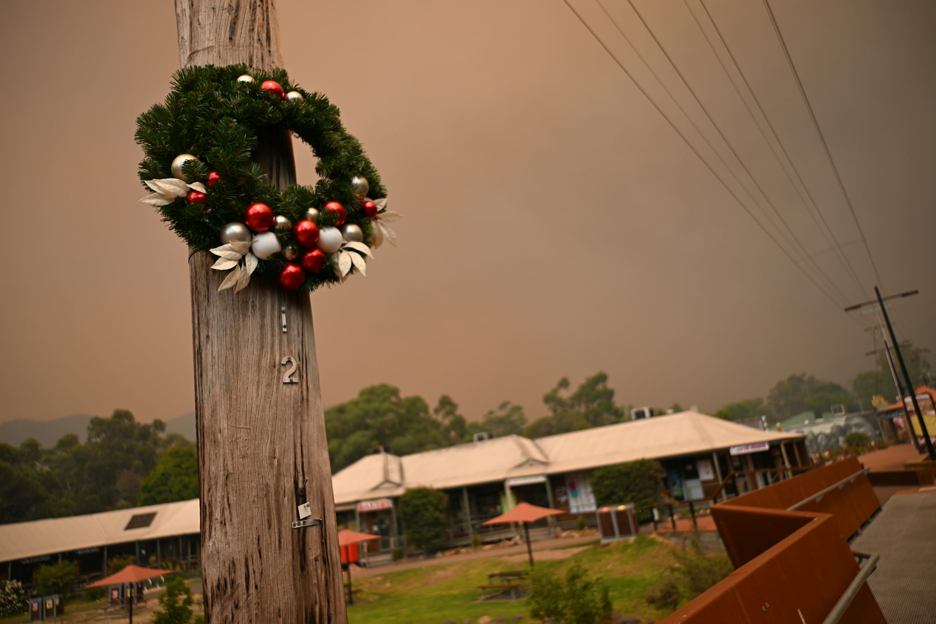A Christmas wreath on a flagpole, with smoky sky behind