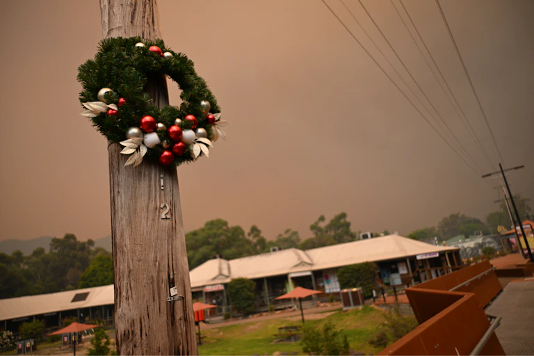 A Christmas wreath on a flagpole, with smoky sky behind