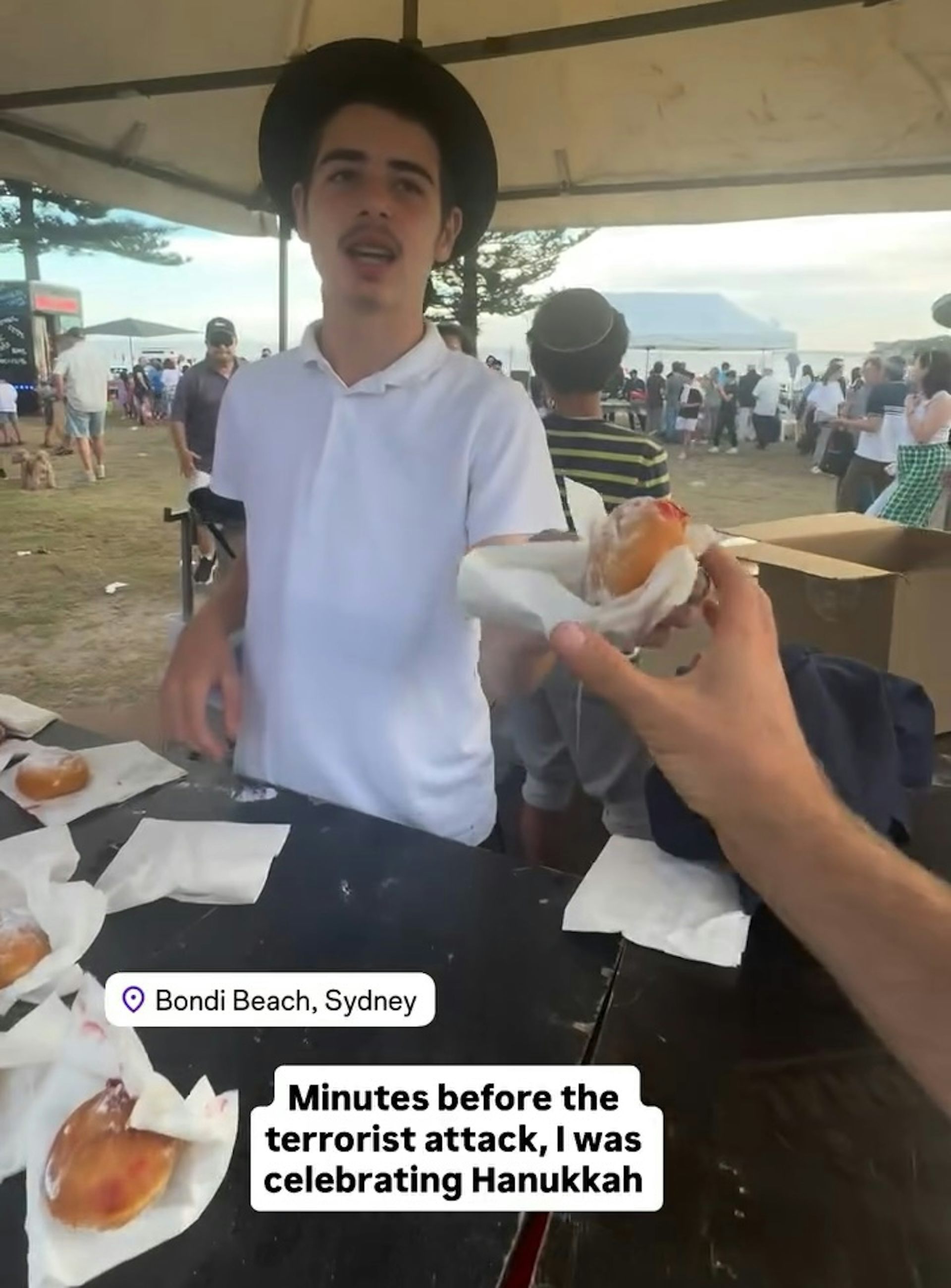 A person handing someone a hot jam donut