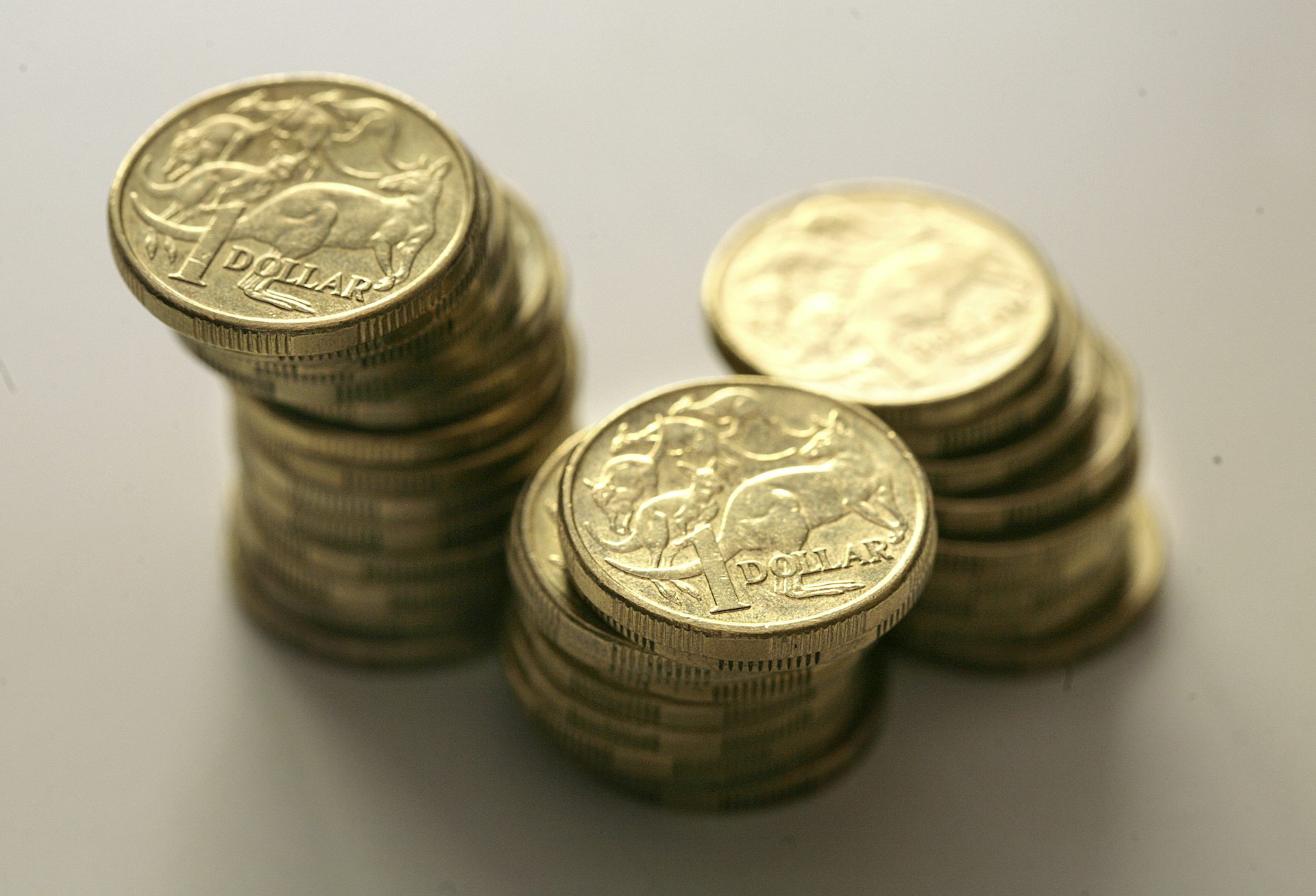 Three piles of stacked $1 dollar coins