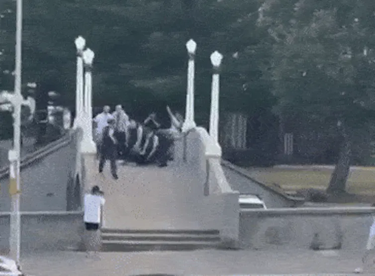 Chaos ensues as bystanders and police rush the bridge.