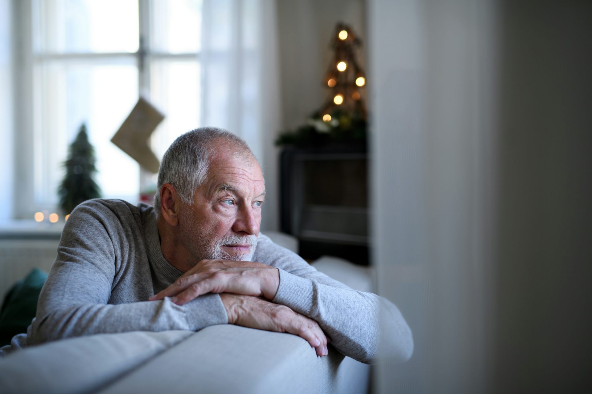 Man sits alone on sofa at Christmas