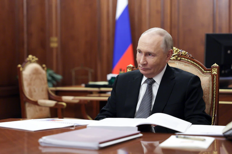 Vladimir Putin sat at a table inside the Kremlin.