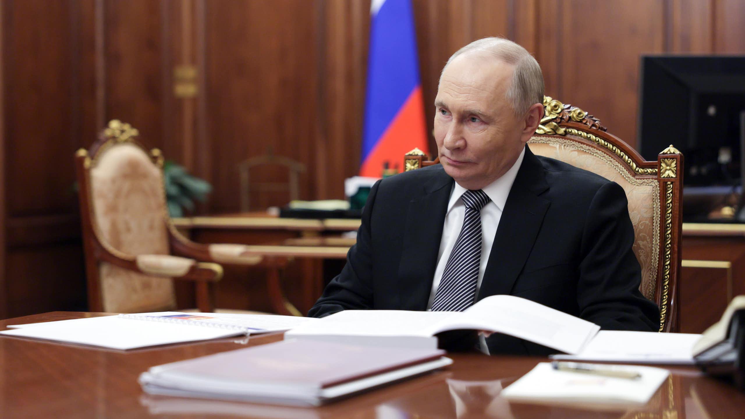 Vladimir Putin sat at a table inside the Kremlin.