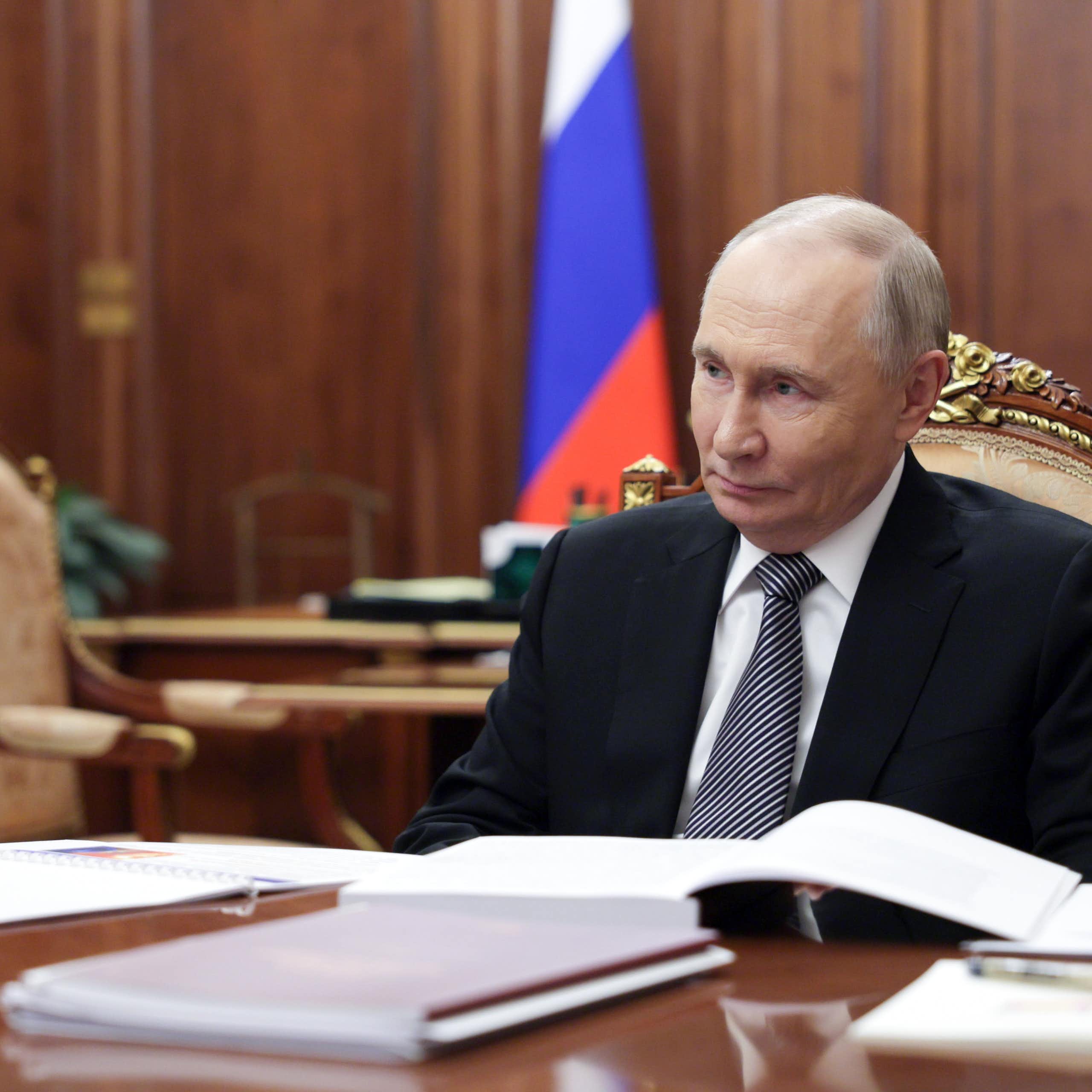 Vladimir Putin sat at a table inside the Kremlin.