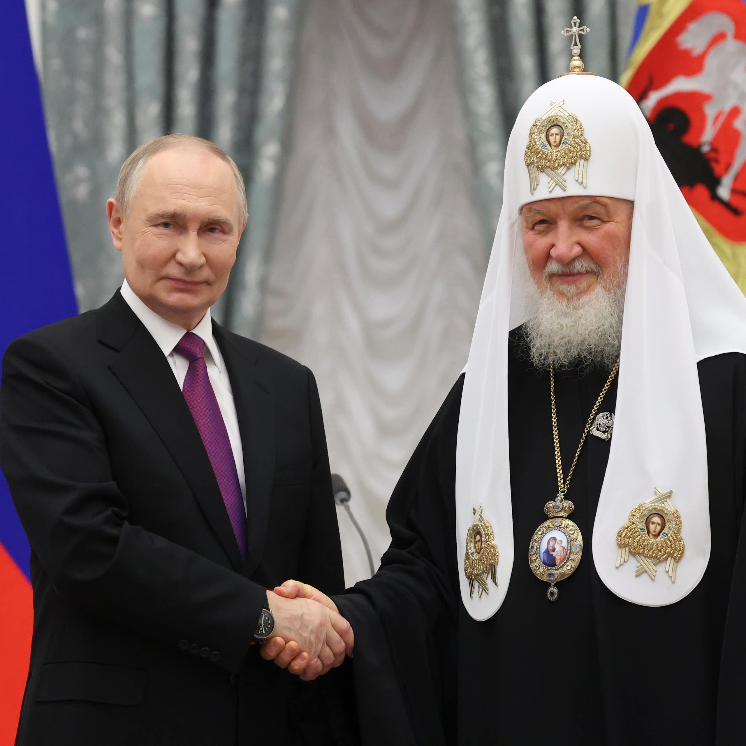 Patriarch Kirill and Vladimir Putin shaking hands.