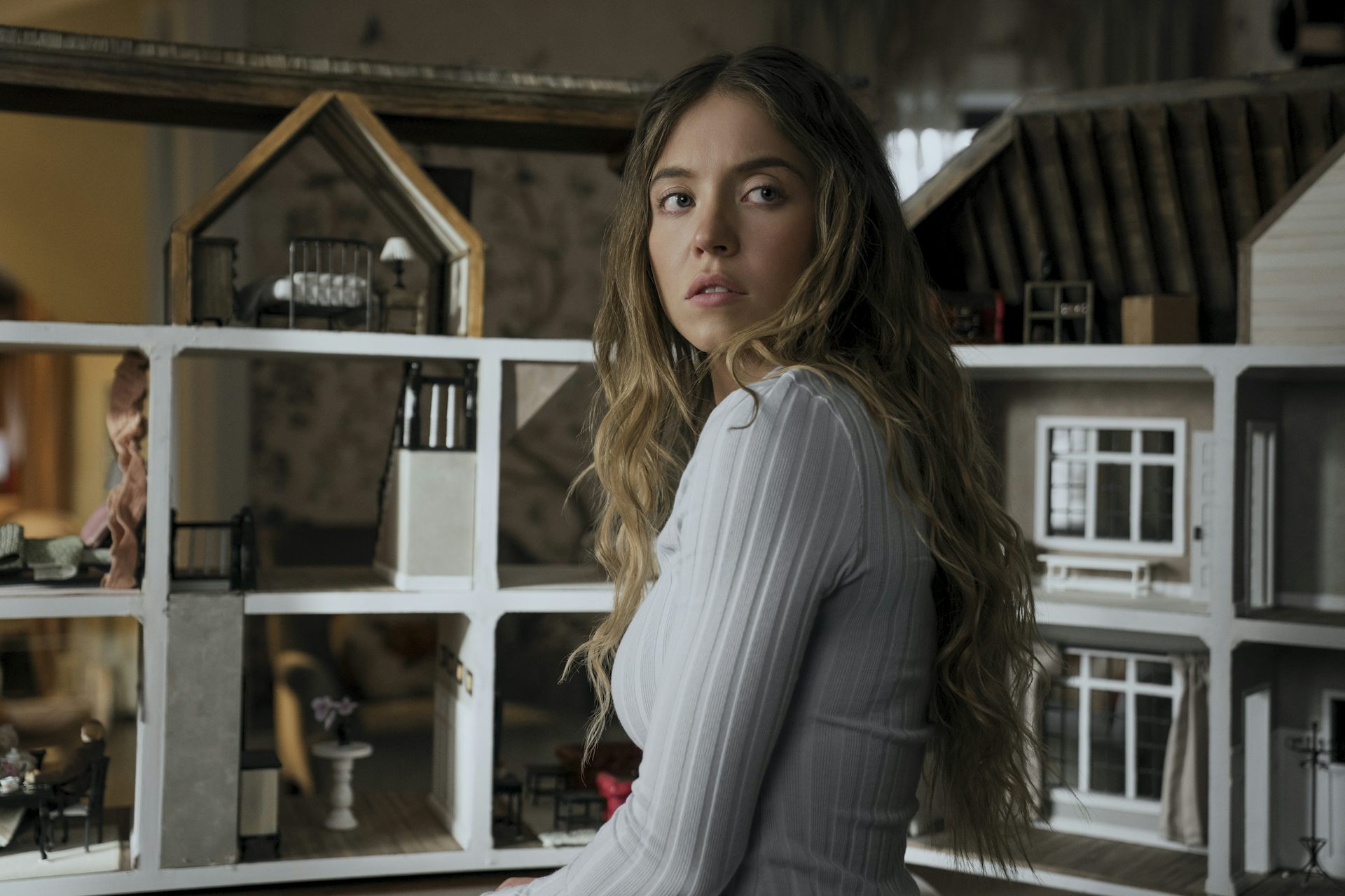 Sydney Sweeney stood in front of a dolls house