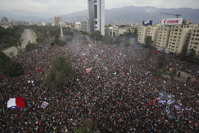 A massive crowd is shown from above during a protest.