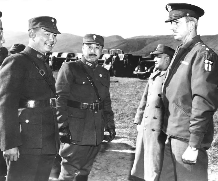 A black and white photo shows Chinese and American military leaders.