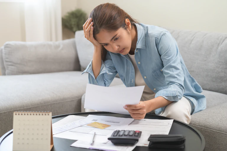Mujer revisando pagos con cara de preocupación.