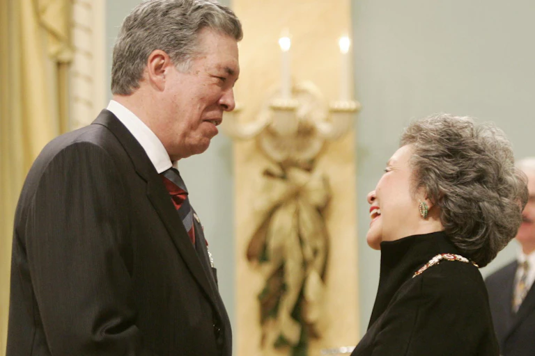 A man in a suit in discussion with a smiling woman.