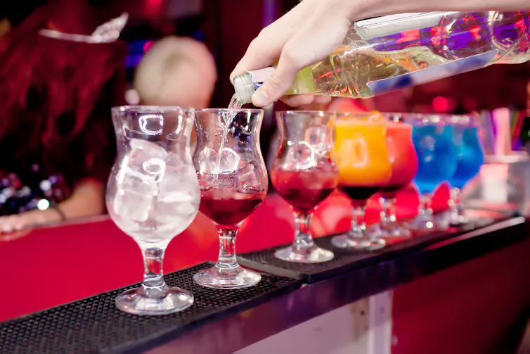 Close up of colourful cocktails being prepared at a bar