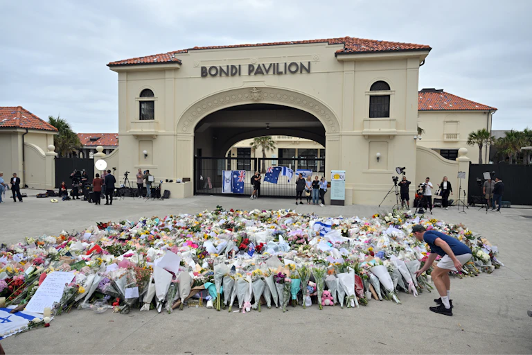 A memorial of flowers in front of a pavillion.