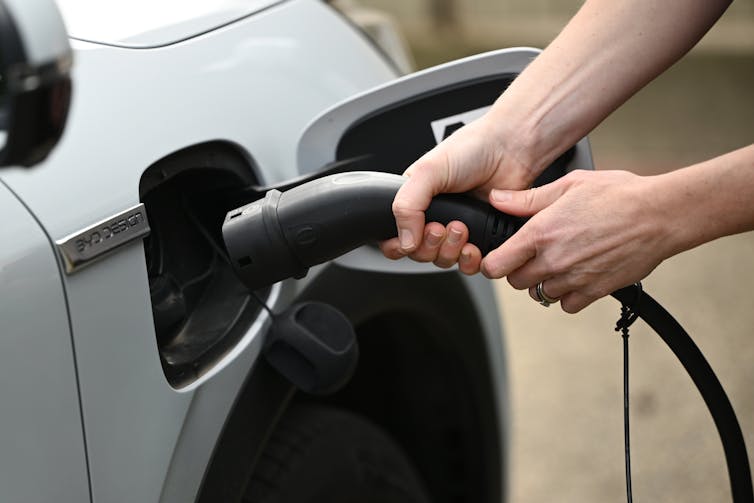 hands holding EV charger
