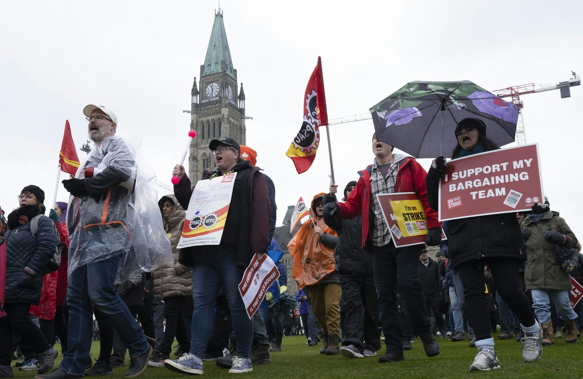 Picketing workers on Parliament Hill with the Peace Tower in the background