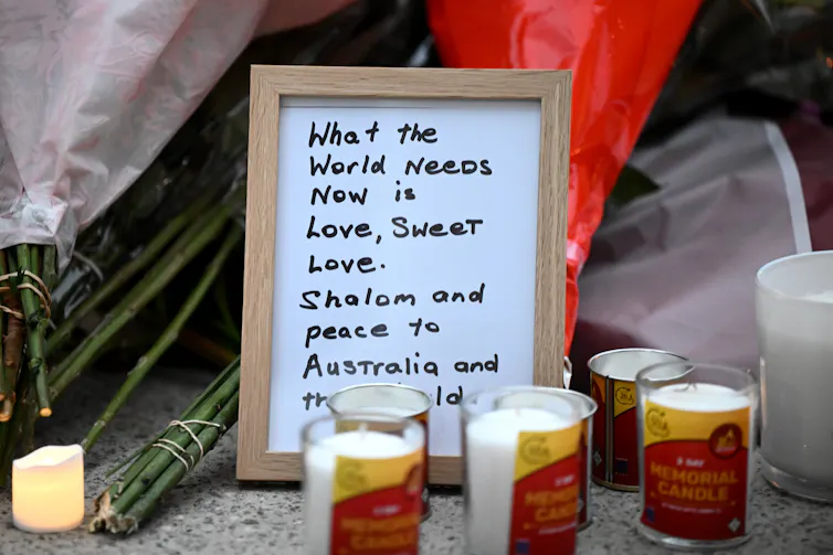 A sign promoting love surrounded by candles.
