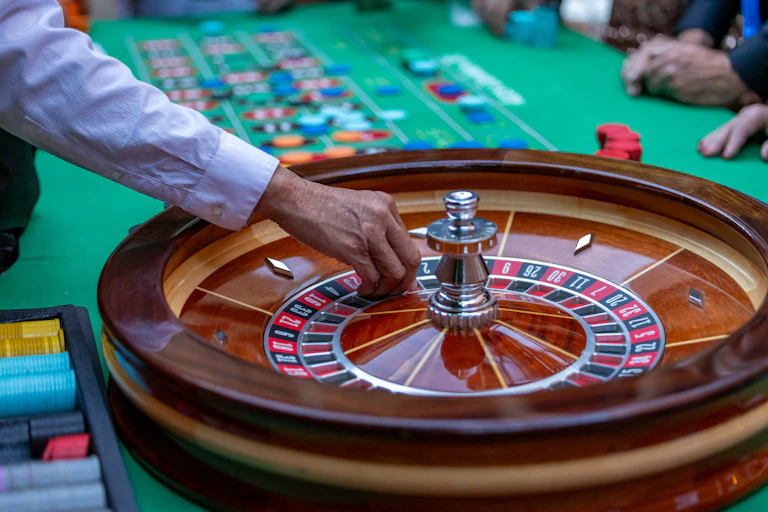 A person placing a ball on a roulette wheel