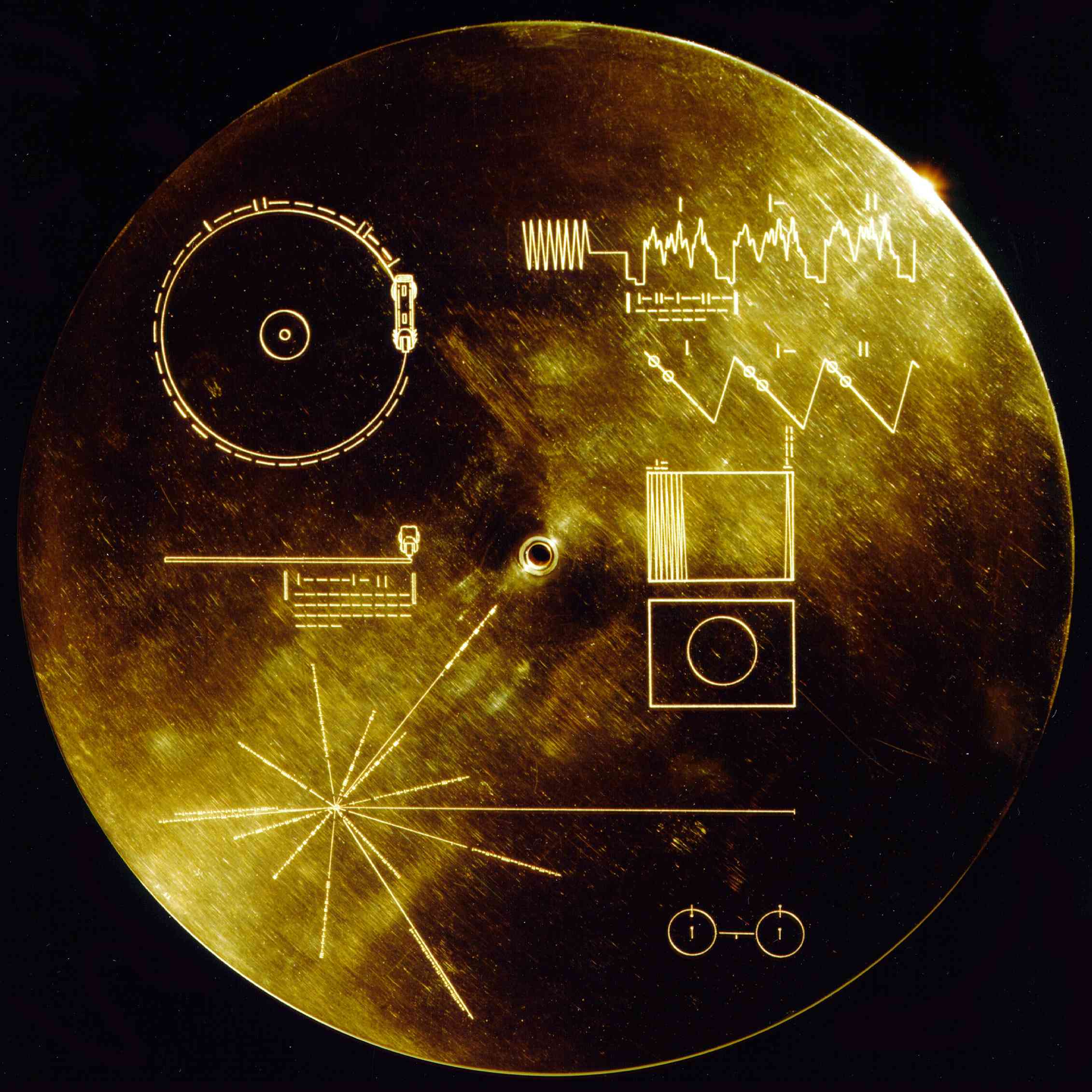 Circular gold-plated cover displaying symbols and diagrams.
