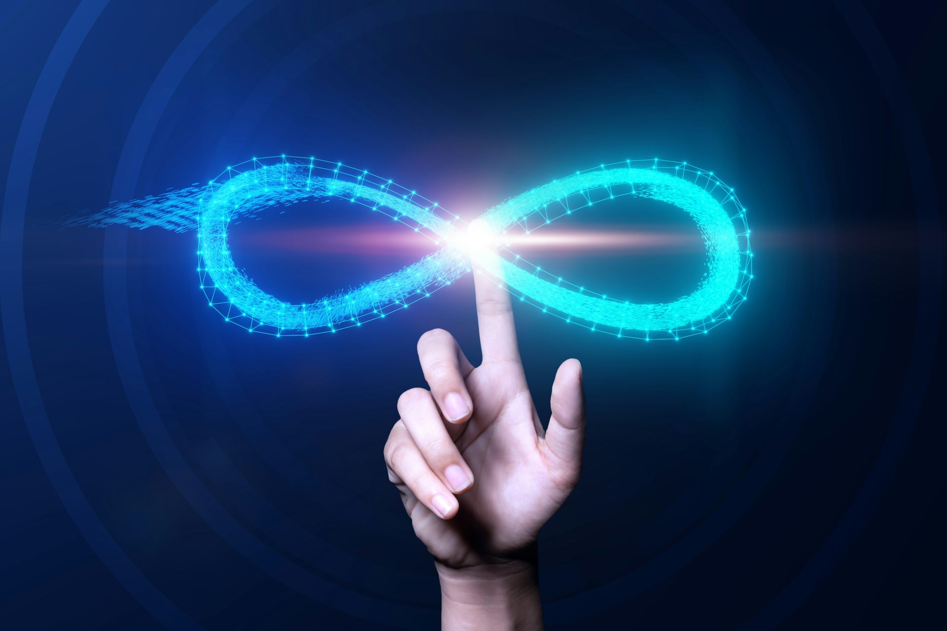 Una mano toca un símbolo luminoso del infinito.