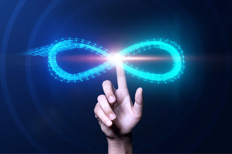 Una mano toca un símbolo luminoso del infinito.