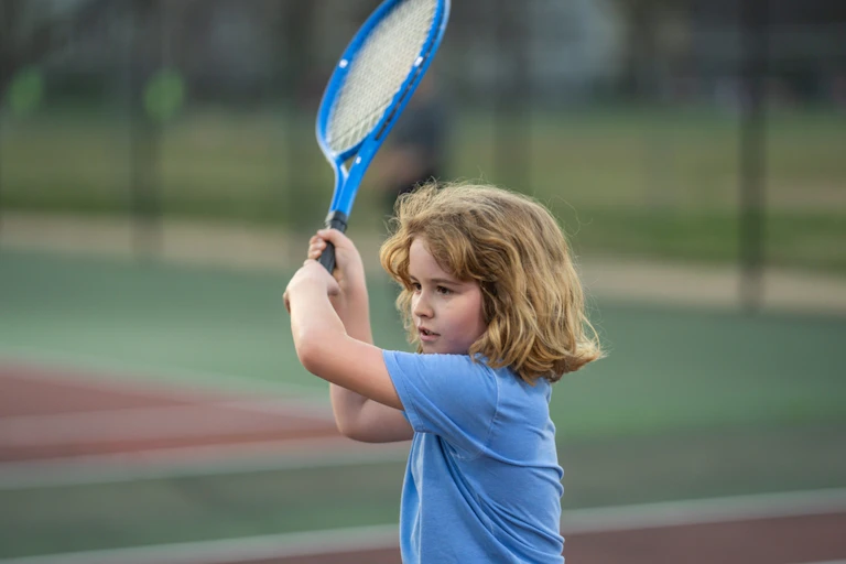 Gros plan sur une petite fille qui joue au tennis