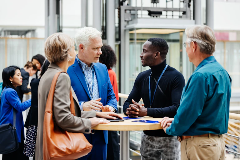 A group of professionals talk to each other in a big foyer.