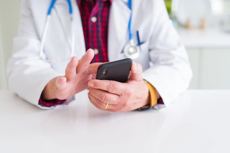 Doctor tapping on his mobile phone.