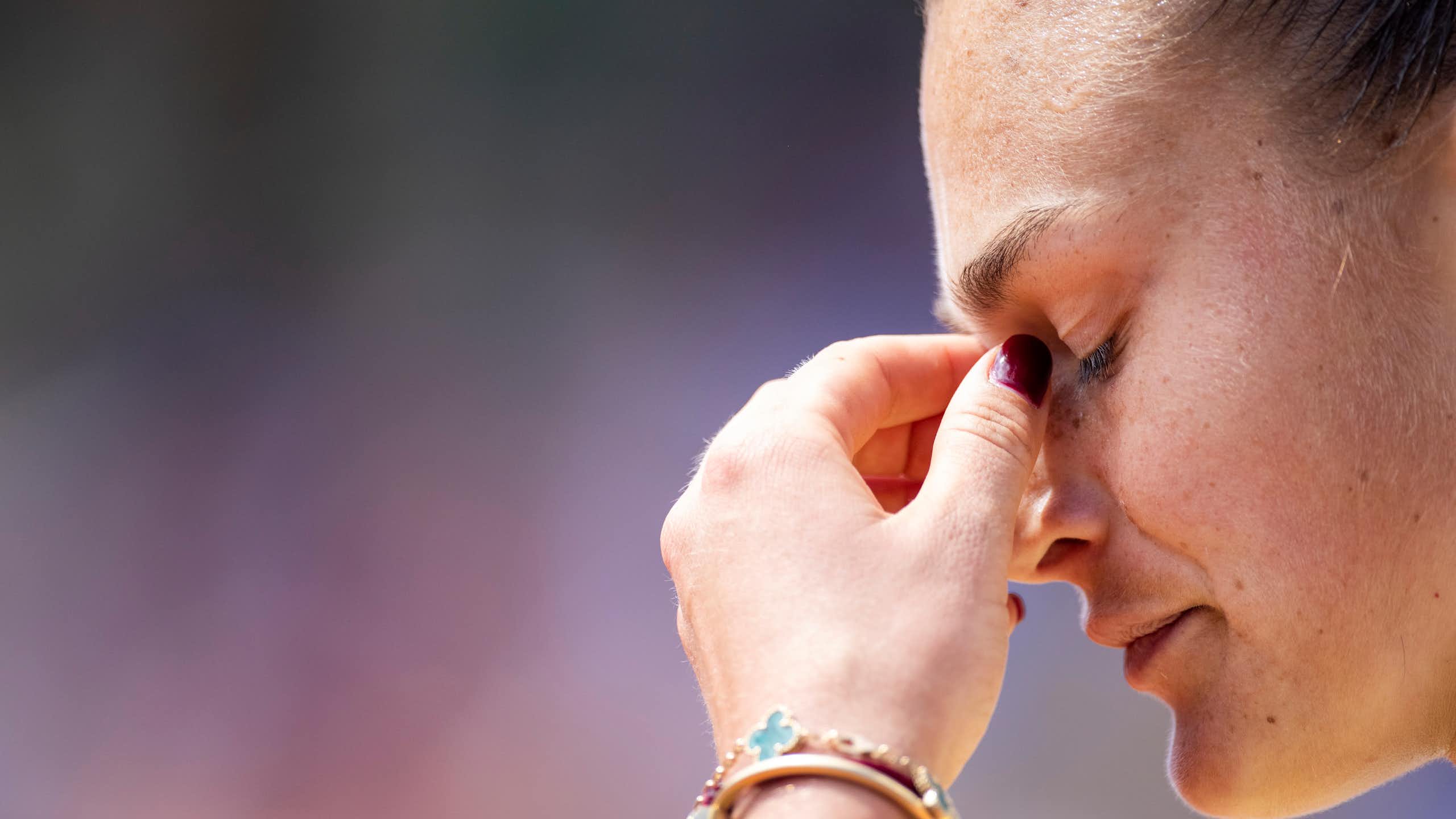 Side profile of your woman with her eyes closed and her hand rubbing her eyes.