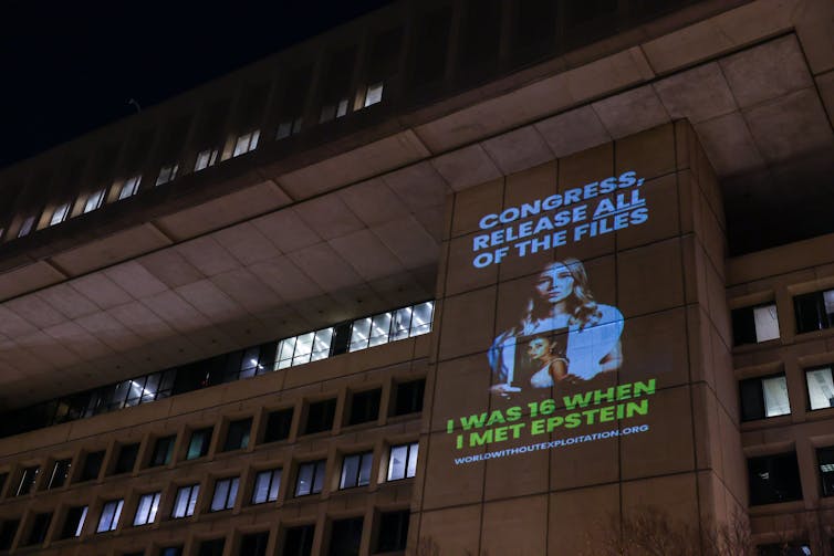 projected image of a woman holding a photo of her younger self. Text underneath reads, 'I was 16 when I met Epstein.'