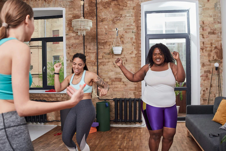 Three women in athleisure clothing dancing