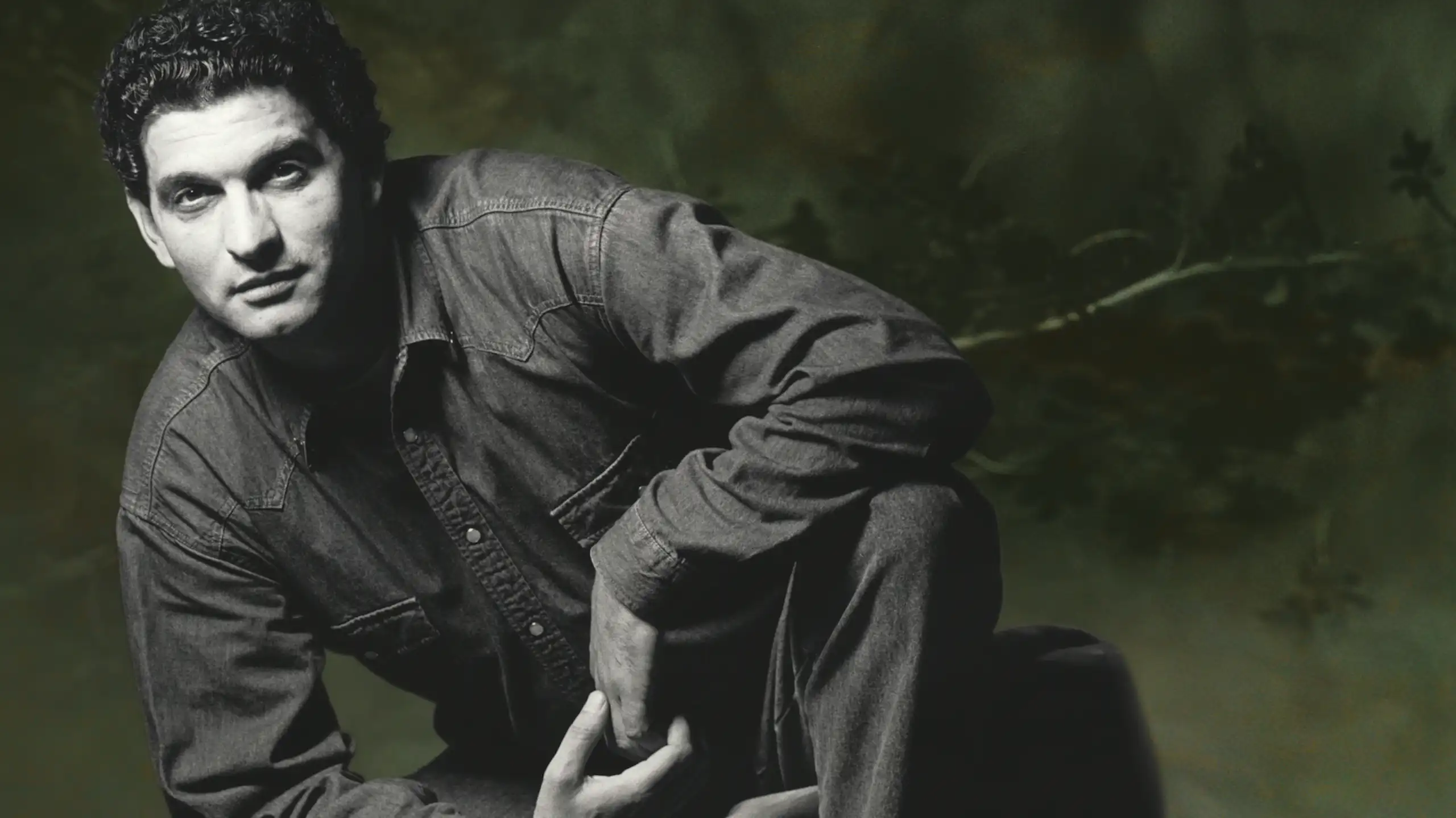 Retrato en blanco y negro de un hombre vestido con camisa vaquera.