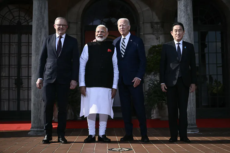 Four men stand for a photo