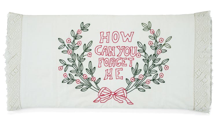 Huge trunks found out in a basement be offering a window into the lives and struggles of early Filipino migrants 4 A white pillowcase with embroidery depicting a bow, green plants and the text 'How Can You Forget Me.'